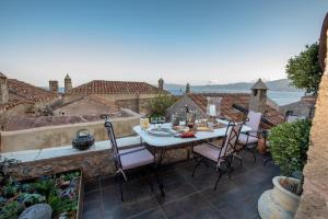 a table and chairs on a patio with a view of the ocean at CASA FELICIA-The Castle Mansion in Monemvasia