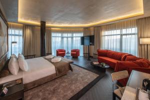 pokój hotelowy z łóżkiem i czerwoną kanapą w obiekcie Hotel Bosfora Plus w Stambule