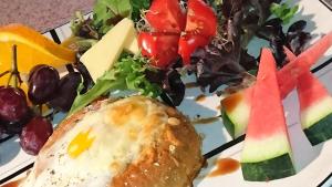 a plate of food with a sandwich and a salad at Chateau Murdock Gite et Esthétique 1950 in Saguenay