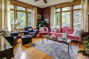 sala de estar con sofá rosado y sillas en Chateau Murdock Gite et Esthétique 1950, en Saguenay