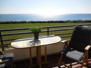 a table and chairs on a balcony with a plant at Lütt Baltic Fehmarn in Staberdorf
