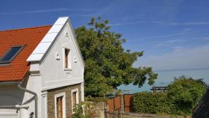 a white house with a red roof at B B Guesthouse TIHANY in Tihany