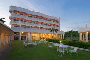a hotel with tables and chairs in front of a building at Marine Lodge Marea in Miyako Island