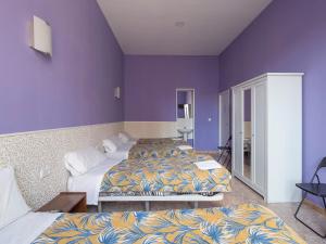 1 dormitorio con 2 camas y pared púrpura en Pensión Apolo XI, en Madrid