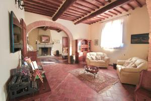ein Wohnzimmer mit Sofas und einem Kamin in der Unterkunft Il Rifugio Del Falconiere in Sovicille