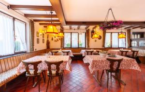 a restaurant with tables and chairs and windows at Pension Schlossbergblick in Simonswald