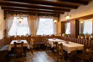 a restaurant with two tables and chairs and windows at Hotel Eleon in Bad Teinach-Zavelstein