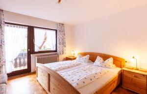 a bedroom with a large bed and a large window at Pension Schlossbergblick in Simonswald