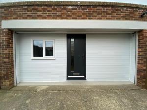 a white garage door with a window in a brick building at Margate Seaside Retreat in Margate
