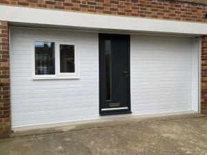 a garage with a black door and a window at Margate Seaside Retreat in Margate