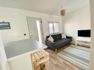 ein Wohnzimmer mit einem Sofa und einem TV in der Unterkunft Margate Seaside Retreat in Margate