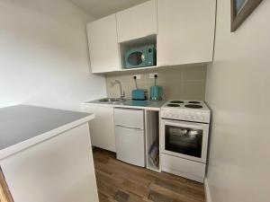 a white kitchen with a stove and a sink at Margate Seaside Retreat in Margate