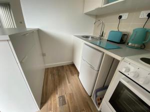 a small kitchen with a sink and a stove at Margate Seaside Retreat in Margate
