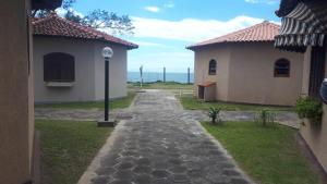 a cobblestone path between two buildings with a street light at Chalé com 2 quartos a Beira Mar in Rio das Ostras
