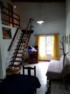 un soggiorno con scala e televisore di Cabañas Cumelen a Potrero de los Funes Altre 19 foto