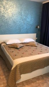 een bed in een slaapkamer met een blauwe muur bij Laguna Albastră Residence in Piatra Neamţ