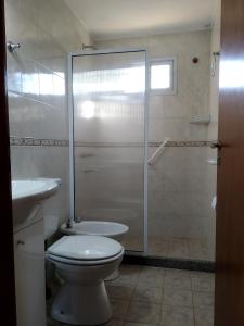 y baño con ducha, aseo y lavamanos. en Cabañas Cumelen en Potrero de los Funes