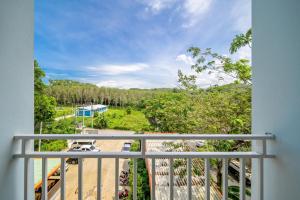 a balcony with a view of a park at Naiyang Place - Phuket Airport in Nai Yang Beach