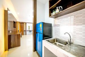 a kitchen with a blue refrigerator and a sink at Naiyang Place - Phuket Airport in Nai Yang Beach