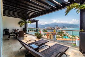a balcony with a view of the ocean and mountains at Shangri La Luxury Penthouse Condominiums by Cheap Getaway in Puerto Vallarta
