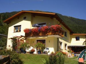 ein Haus mit Blumenkästen an der Seite in der Unterkunft Ferienwohnung Maier in Flattach