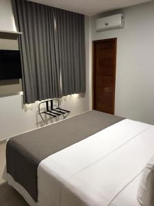 a bedroom with a large white bed and a window at Hotel Barreto in Nossa Senhora da Glória