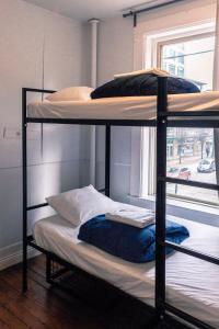 two bunk beds in a room with a window at The Cambie Hostel Seymour in Vancouver
