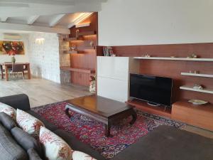 a living room with a couch and a flat screen tv at Palazzo GiuFa in Syracuse