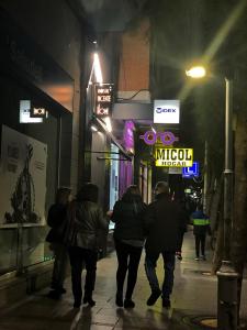 a group of people walking down a street at night at Vicente Home in Alcantarilla