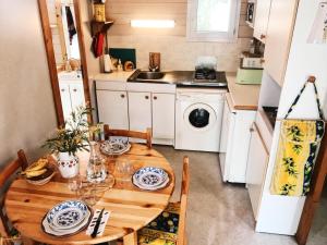 eine kleine Küche mit einem Holztisch und Stühlen in der Unterkunft Chalet à Gassin au calme sous les pins in Gassin