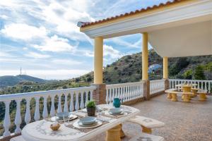 balkon ze stołem i naczyniami w obiekcie Villa Olympo w mieście Torrox