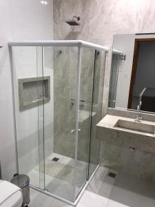 a bathroom with a glass shower and a sink at Hotel Barreto in Nossa Senhora da Glória