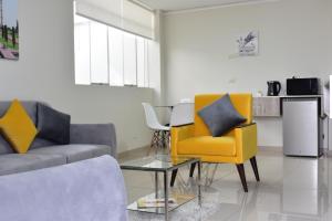 un soggiorno con divano e 2 sedie di MUNAY TTIKA Hoteles a Moquegua
