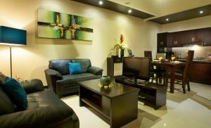 a living room with a couch and a tv and a table at My Villas In Bali in Seminyak