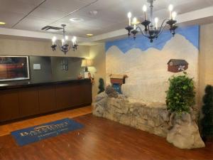 a lobby with a stone wall with a house on it at Baymont Inn & Suites in Marietta