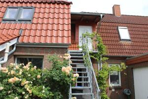 une maison au toit rouge avec un escalier devant elle dans l'établissement Ferienwohnung Nixe, à Sandstedt