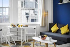 een woonkamer met een bank en een tafel bij Studio Apartment by Homely Stays in Londen