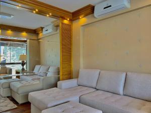 sala de estar con sofá, sillas y TV en Garibaldi 402 - Gramado (30 metros Rua Coberta), en Gramado