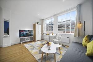 een woonkamer met een bank en een tafel bij Studio Apartment by Homely Stays in Londen