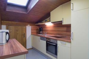 a kitchen with white appliances and a wooden ceiling at Apart EVA in Serfaus