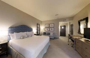 a bedroom with a bed and a desk and a computer at The Inn by Sea Island in Saint Simons Island