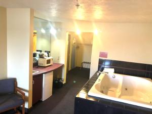 a bathroom with a large tub in a room at Travelodge by Wyndham Grand Island in Grand Island