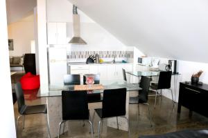 a kitchen with a glass table and black chairs at Madeira Native Motion Apartment in Ponta do Pargo