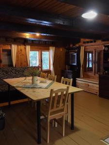 eine Küche und ein Esszimmer mit einem Holztisch und Stühlen in der Unterkunft Chata Boca Salašky in Nižná Boca