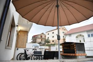 un parasol installé sur une terrasse avec une table et des chaises dans l'établissement Apimonte City House A, à Bragance