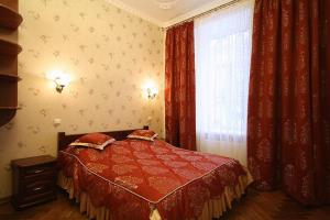 a bedroom with a red bed and a window at Park and Opera Apartments in Lviv