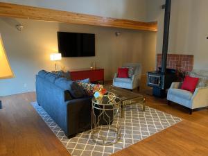 a living room with a blue couch and a tv at Der Sportsmann Suites in Leavenworth