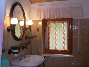 a bathroom with a sink and a mirror and a window at Mansarda in montagna in Abetone