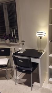 a black and white desk with a lamp and chairs at Birkerød Rolighedsvej 14A in Birkerød