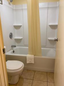 a bathroom with a toilet and a tub and a sink at Best Inn in Augusta